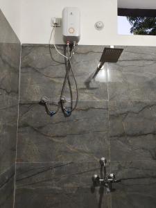 a shower in a bathroom with a camera on the wall at Madan Usha Resort in Chitrakoot