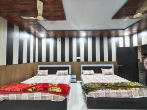 two beds in a room with black and white stripes at Madan Usha Resort in Chitrakoot