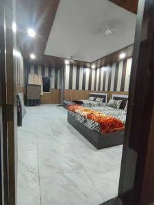 a room with two beds and a television in it at Madan Usha Resort in Chitrakoot