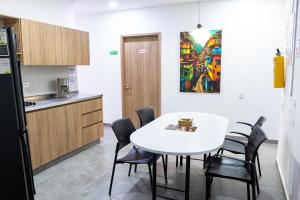 a kitchen with a white table and black chairs at Komfort House Premium in Medellín