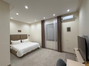 a bedroom with a bed and a television in it at Hotel Bogatt in Dushanbe