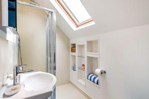 a bathroom with a white sink and a skylight at 3 Bed in Felixstowe oc-h32096 in Walton +8 photos
