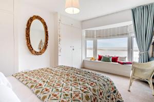 a bedroom with a bed and a mirror and a window at 3 Bed in Felixstowe oc-h32096 in Walton