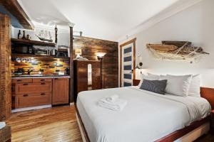 a bedroom with a white bed and a kitchen at Le Ricochet Urbain in Quebec City