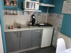 a small kitchen with a sink and a microwave at Chez Isa in Saint-Martin-Boulogne