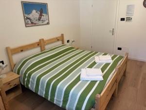 a green and white bed with two towels on it at Affittacamere Penasa in Rabbi