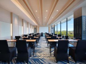 a dining room with tables and chairs and windows at Mercure Berau in Tanjungredep +64 photos