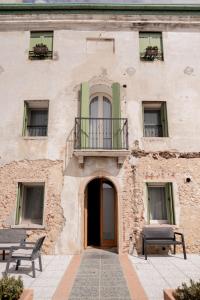 a building with two benches in front of it at locazione turistica PetitePomme in Borso del Grappa
