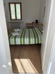 a bedroom with a bed with a green and white stripes at Affittacamere Penasa in Rabbi +2 photos