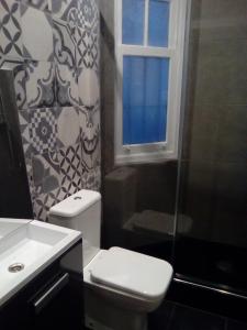 baño con aseo y lavabo y ventana en Jan&Joan Apartment, en Bilbao