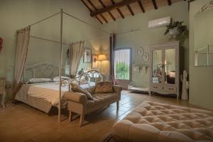 a bedroom with a canopy bed and a couch at Il Borgo delle Pampare in Campello sul Clitunno