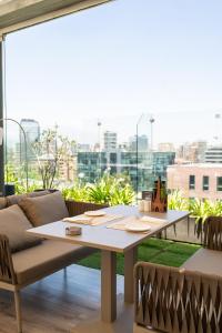 a table and chairs in a room with a large window at NOI Vitacura in Santiago +47 photos