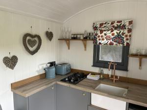 a kitchen with a sink and a stove and a window at Tower Farm Holidays - Glamping in Llangollen +30 photos