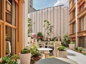 an outdoor patio with tables and chairs and plants at TRIBE Paris Pantin in Pantin