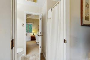 a white bathroom with a toilet and a hallway at Seasons 308 in Warren +11 photos
