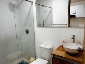 a bathroom with a shower and a toilet and a sink at Apartamento floral in Tunja