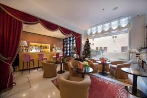 a hotel lobby with a christmas tree and tables and chairs at Hotel A La Commedia in Venice