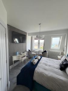 a bedroom with a large bed with a desk and chairs at Lazy Waves in Newquay