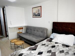 a bedroom with a bed and a couch at Apartamento floral in Tunja