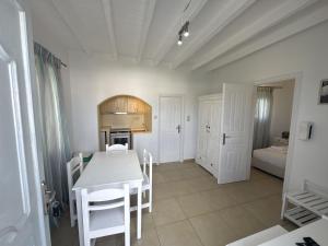 a kitchen with a white table and chairs in a room at Casa Bianca in Ornos