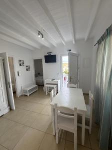 a white dining room with a white table and chairs at Casa Bianca in Ornos