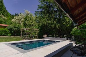 a swimming pool in a yard with a table and chairs at Adventure Cottage with pool and big garden in Bled