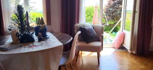a dining room with a table and chairs and a window at Gîte La petite maison 2 ch bain nordique privé Skadi & sauna in Les Fontenelles +10 photos