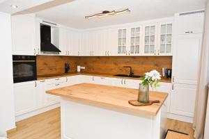 a kitchen with white cabinets and a wooden counter top at Villa NOA in Jajce
