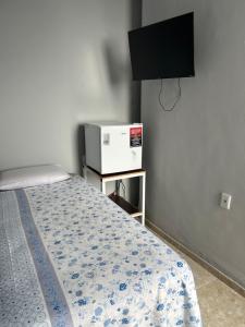 a bedroom with a bed and a television on a wall at Pousada das Redes in João Pessoa