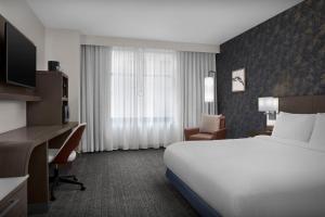 a hotel room with a bed and a desk at Courtyard by Marriott Richmond Downtown in Richmond +35 photos