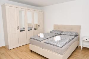 a white bedroom with a large bed and cabinets at Villa NOA in Jajce