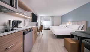 a hotel room with a bed and a kitchen at Hyatt Studios Chesapeake in Chesapeake