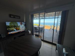 a living room with a table and a television and a balcony at ALMAR House in Guaquen