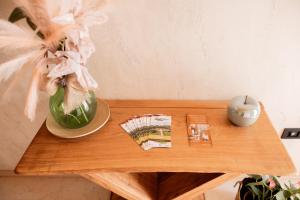 a wooden table with a vase and a book on it at locazione turistica PetitePomme in Borso del Grappa