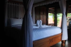 a bedroom with a bed with a canopy at Villa Intan 2 in Amed +67 photos