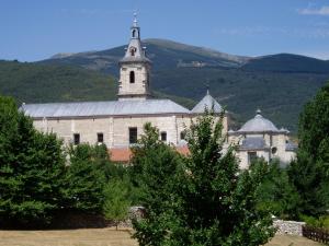 Un gran edificio blanco con una torre encima. en Hotel Rural El Valle, en Rascafría