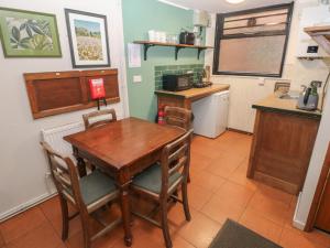 a kitchen with a wooden table and a counter at Cabin No 2 - Salt and Fern Cabins in Port Talbot +15 photos
