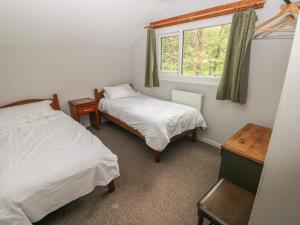 a bedroom with two beds and a window at Cabin No 2 - Salt and Fern Cabins in Port Talbot