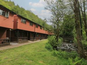 a building with a river in front of it at Cabin No 2 - Salt and Fern Cabins in Port Talbot