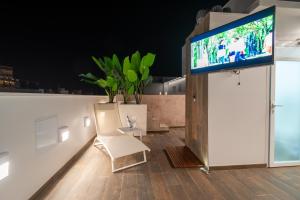 a living room with a tv and a white chair at MUNDOBOOKING Centro Levante in Benidorm