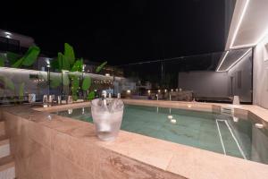 a drink sitting on the edge of a swimming pool at night at MUNDOBOOKING Centro Levante in Benidorm
