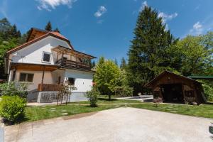 a house with a balcony and a yard at Adventure Cottage with pool and big garden in Bled