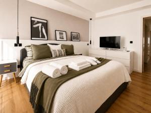 a bedroom with a large bed with towels on it at Luxe-Design Imperio II- Petit Déjeuner 5min de la Mer in Praia