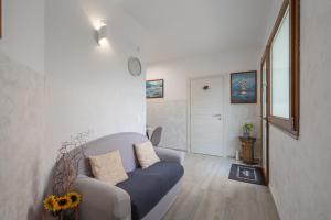 a living room with a blue couch and a door at L'Aurora Porto Torres in Porto Torres