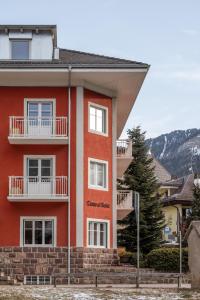 a red building with balconies on the side of it at Casa al Sole in Ortisei
