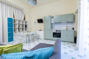 a kitchen with blue cabinets and a couch in a room at Il Veliero Blu Suite Lipari Centro - Corso Vittorio Emanuele in Lipari