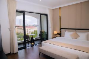 a hotel room with a bed and a large window at The Manor Hotel in Nam Ðịnh +44 photos