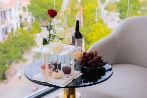 a glass table with food and a bottle of wine at The Manor Hotel in Nam Ðịnh