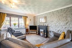 a living room with two couches and a fireplace at 3 Bed in Llanfairpwll oc-22999 in Llanfairpwllgwyngyll