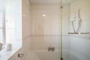 a bathroom with a shower and a bath tub at 3 Bed in Llanfairpwll oc-22999 in Llanfairpwllgwyngyll +14 photos